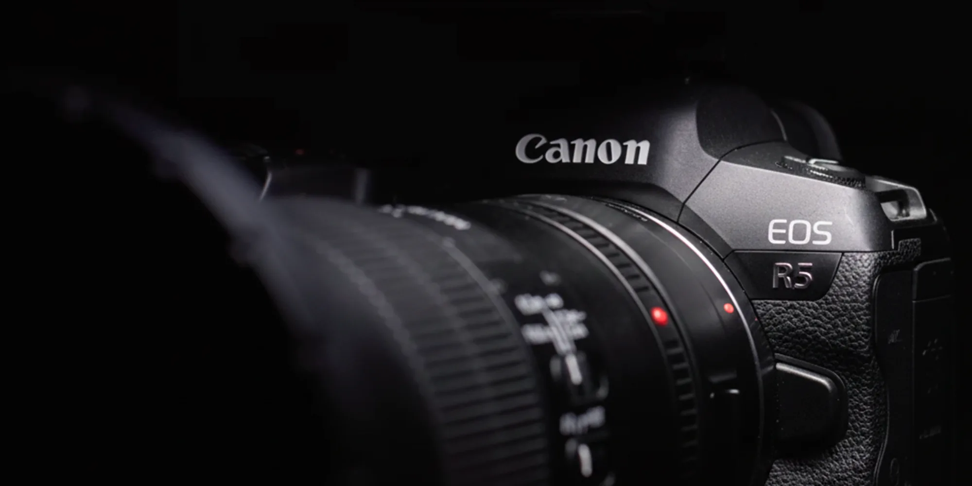 Gros plan cinématique d'un boîtier hybride Canon EOS R5 sur fond noir