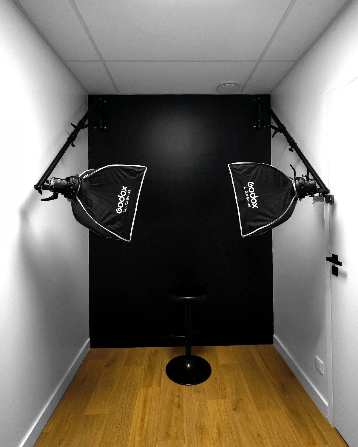 Studio de photographie dentaire installé par U-SHOOT — cabine fond noir, softbox sur bras muraux, environ 6 m².
